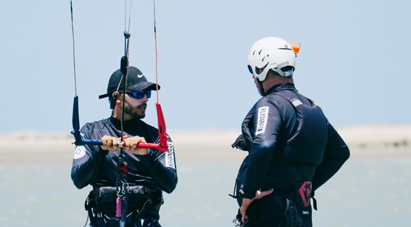 Instrutor orientando aluno de kitesurf antes de entrar no mar