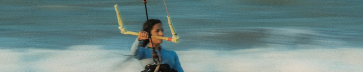 Praticante de kitesurf controlando as linhas da pipa